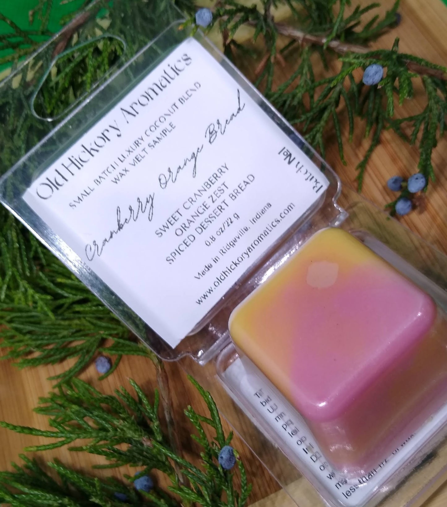 Old Hickory Aromatics Cranberry Orange Bread Wax Melt Sample in packaging on a wooden surface with greenery.